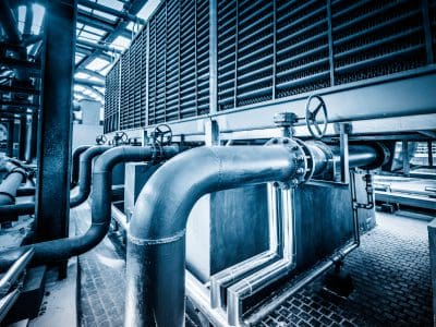 Industrial metal pipes and valves in a factory setting.