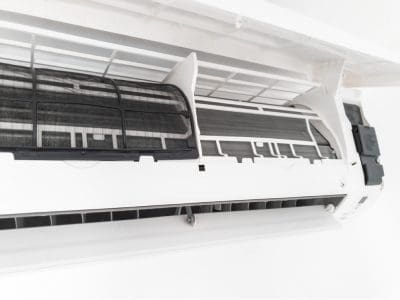 Close-up of an open air conditioner indoor unit revealing internal filters.