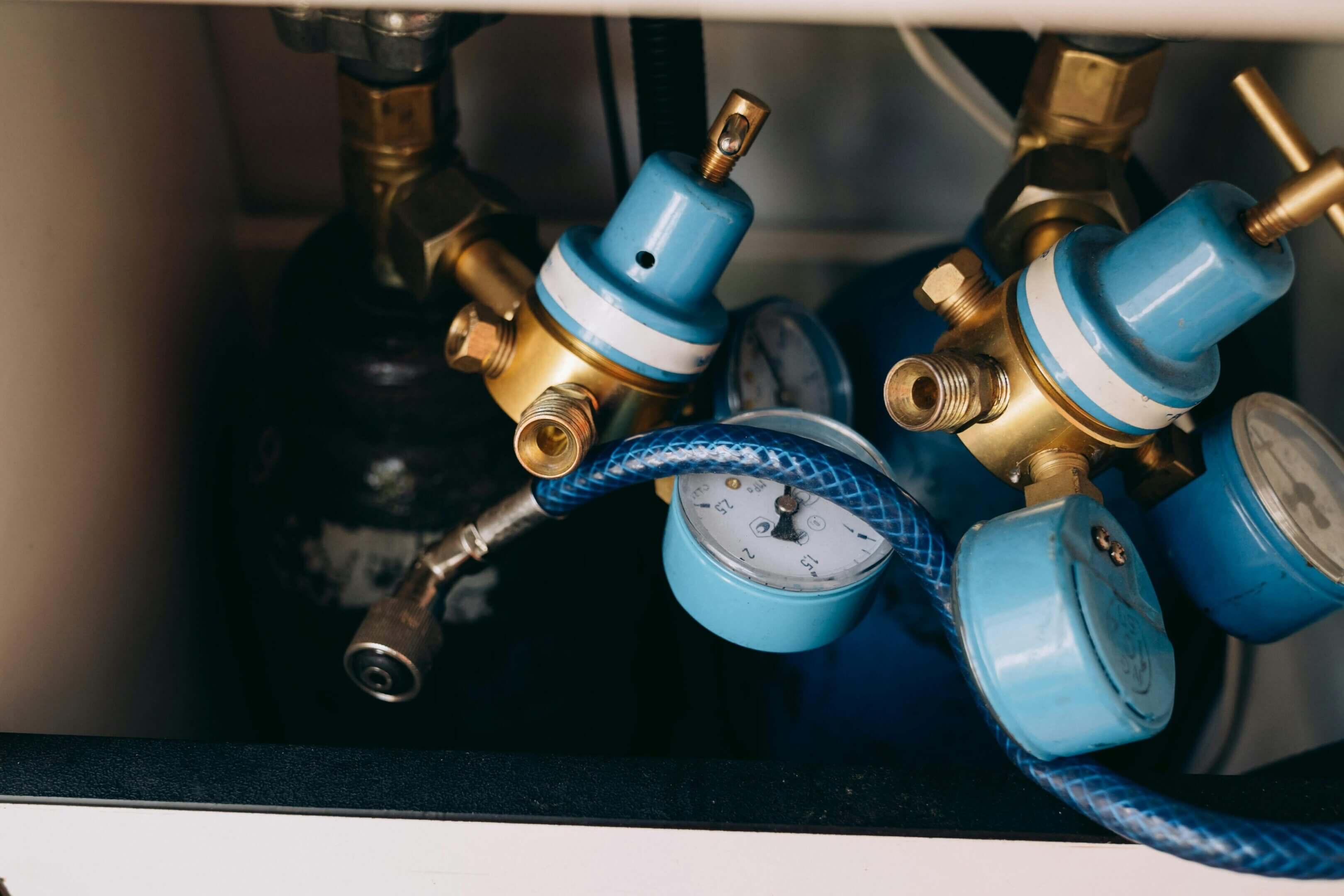 Close-up of blue water pressure gauges with brass fittings.