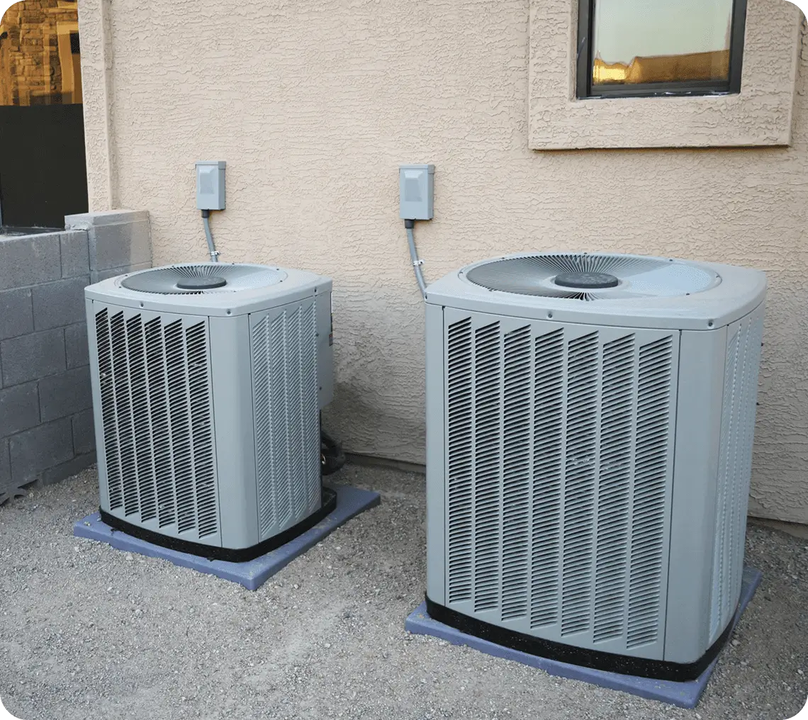 Two outdoor air conditioning units on ground.