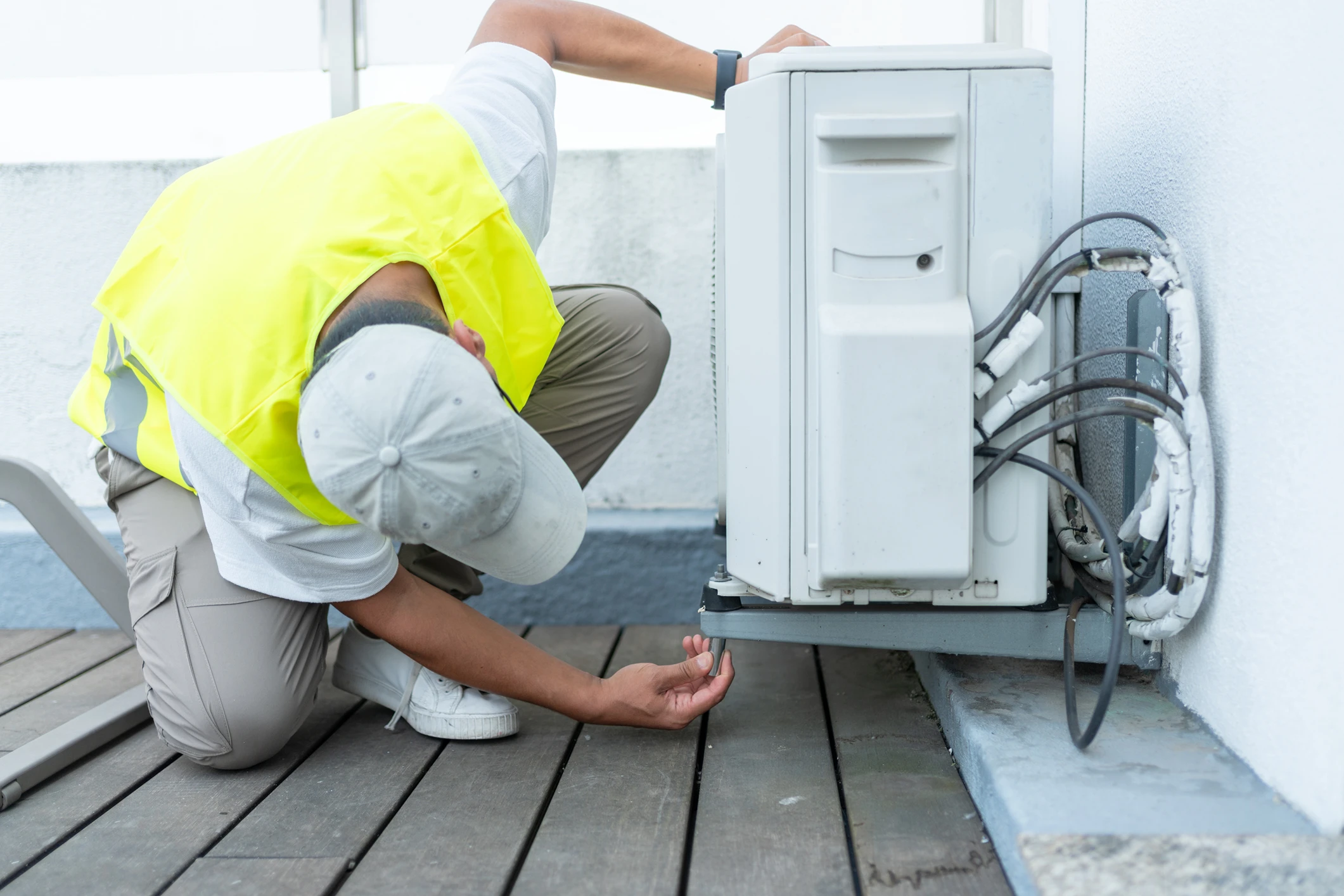 Technician repairing outdoor air conditioning unit.