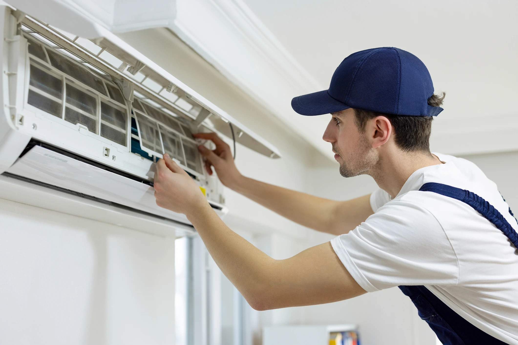 Technician servicing a wall-mounted air conditioner.