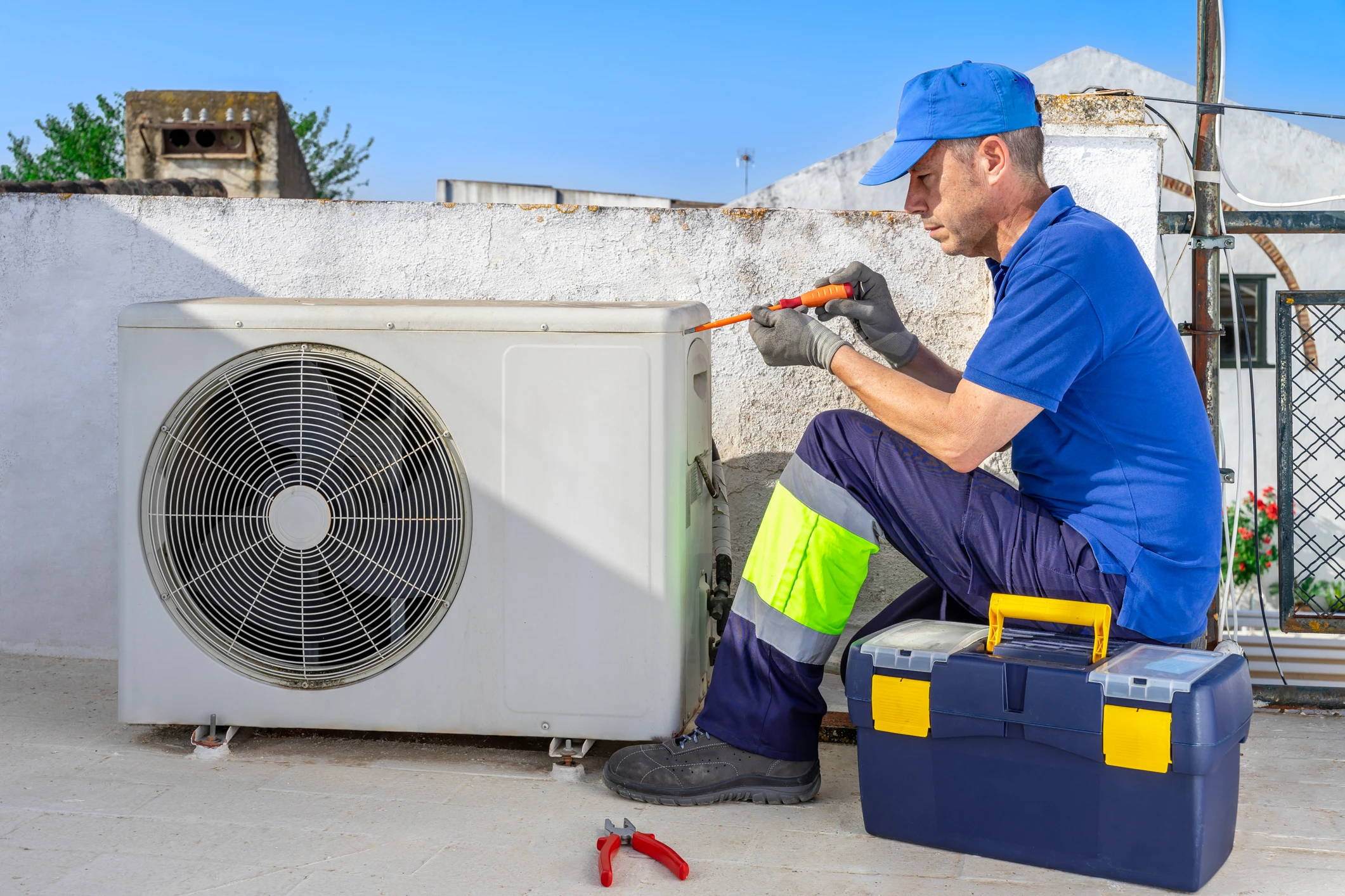 Technician repairing outdoor air conditioning unit.
