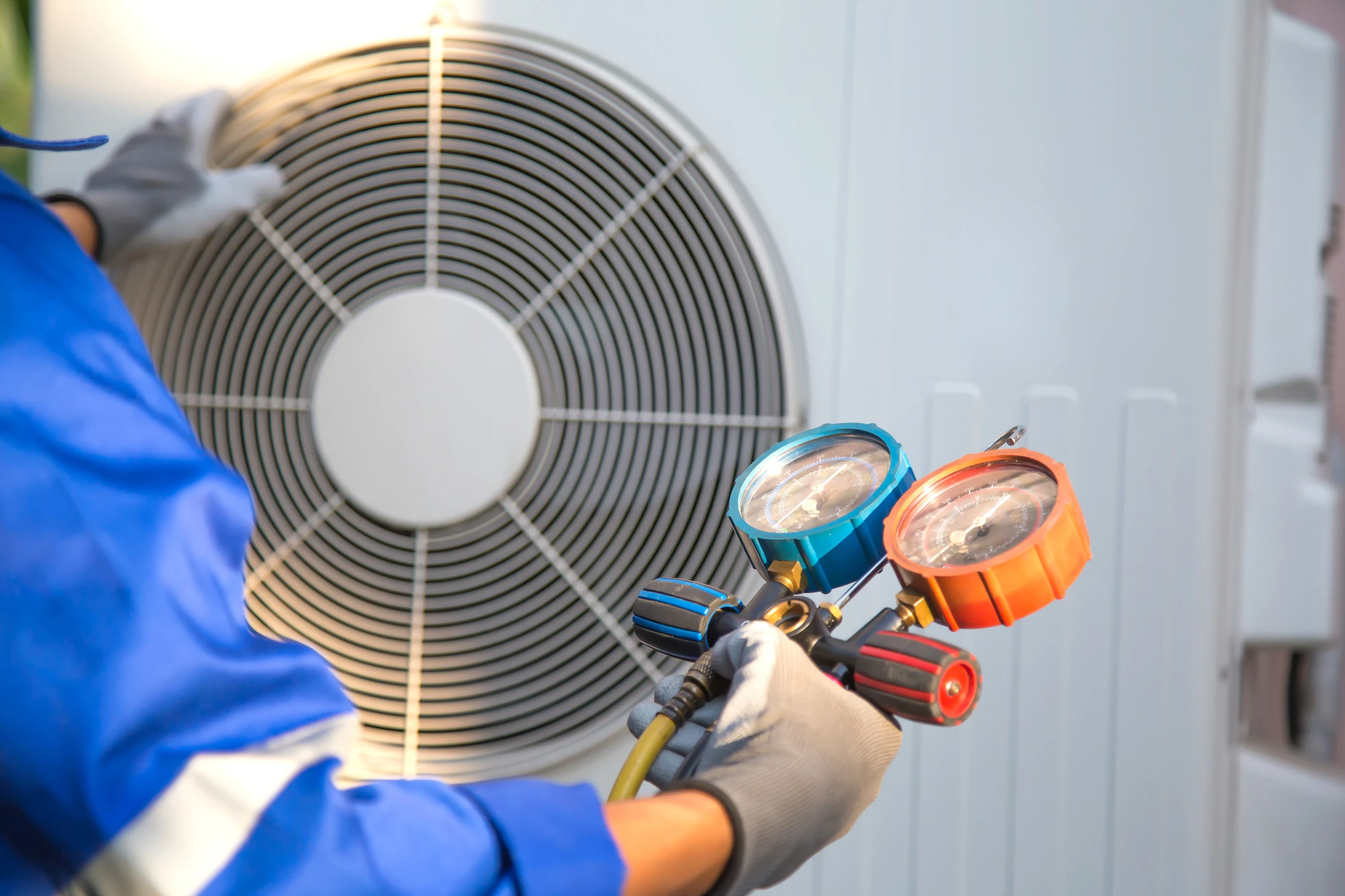Technician checking air conditioning unit pressure.