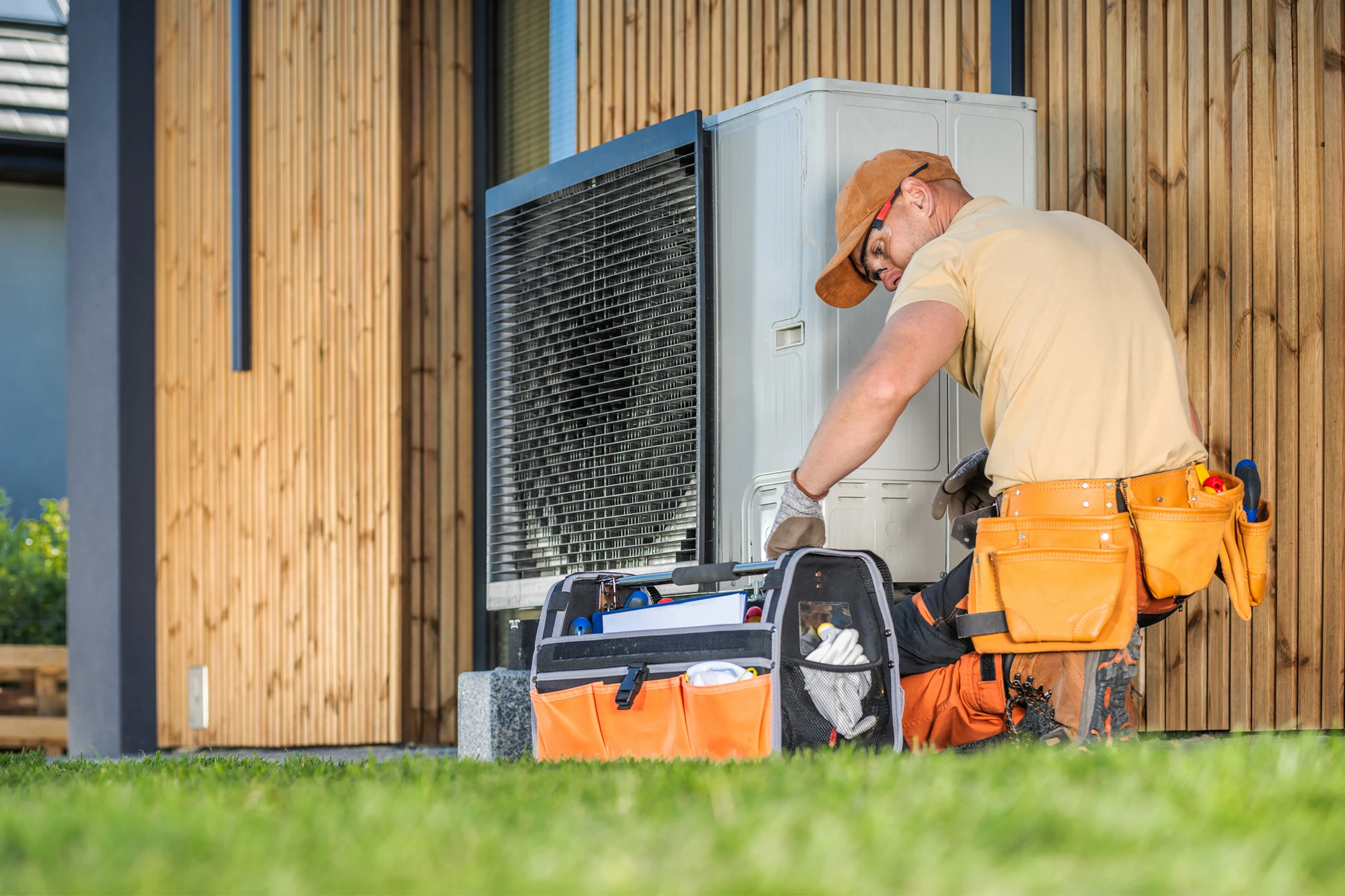 Technician working on outdoor air conditioning unit.