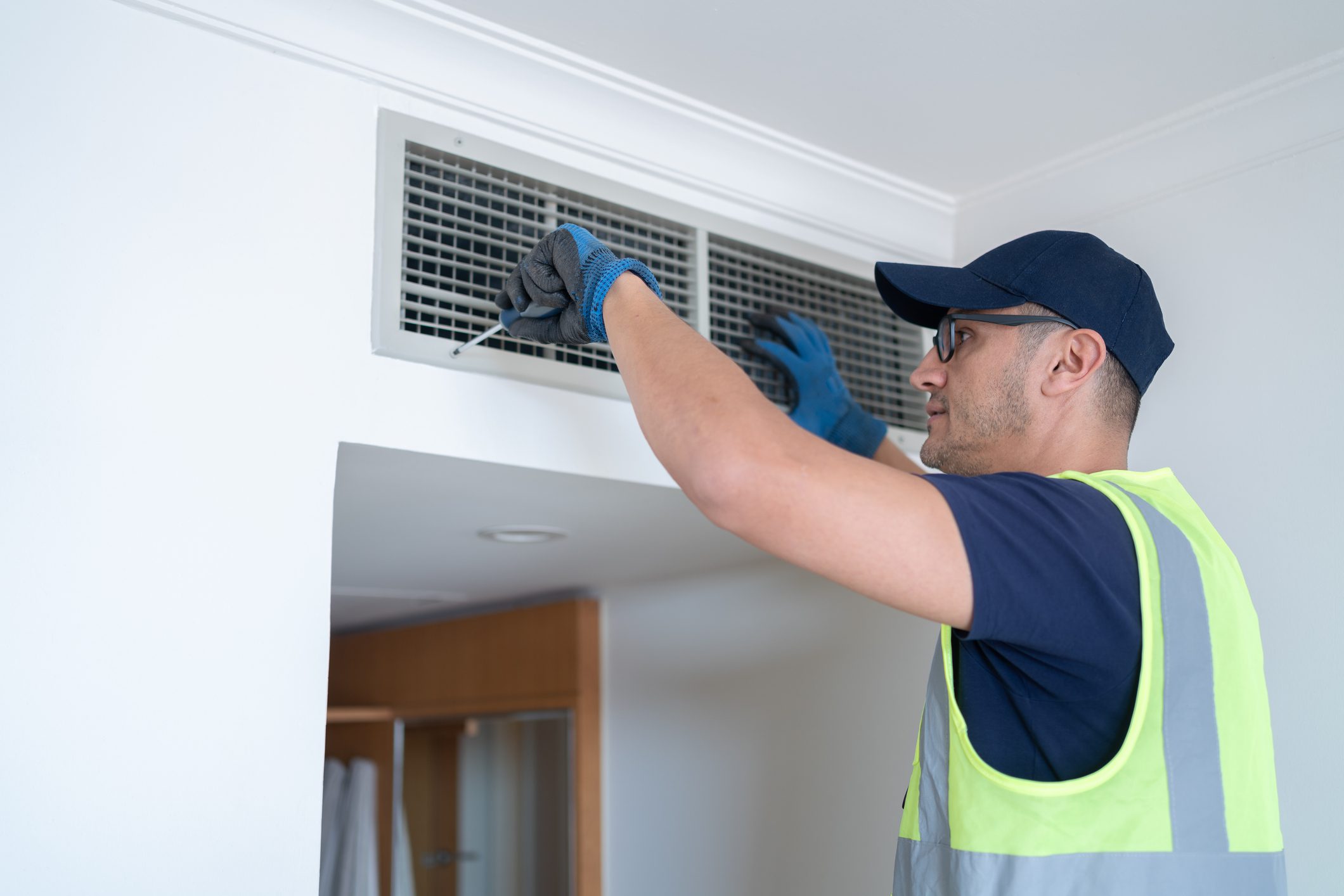 Technician fixing air vent on ceiling.