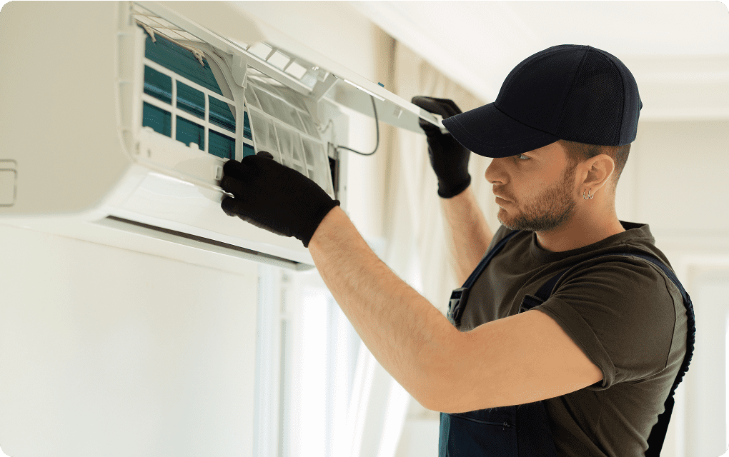 Technician servicing a wall-mounted air conditioner.