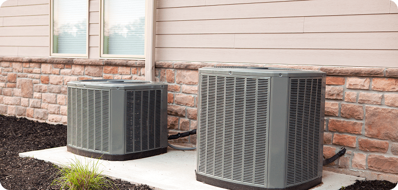 Outdoor air conditioning units beside a house.