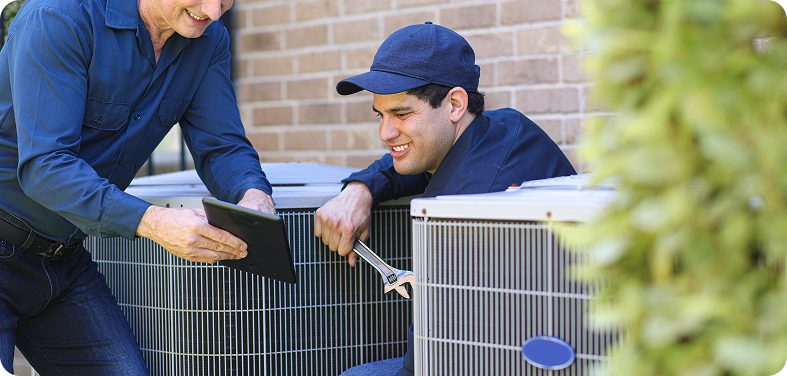 Technicians working on air conditioning units outside.